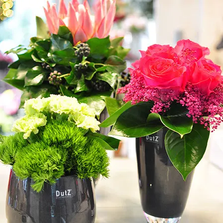 Strauß mit grünen Nelken und rosa Rosen in einer Vase