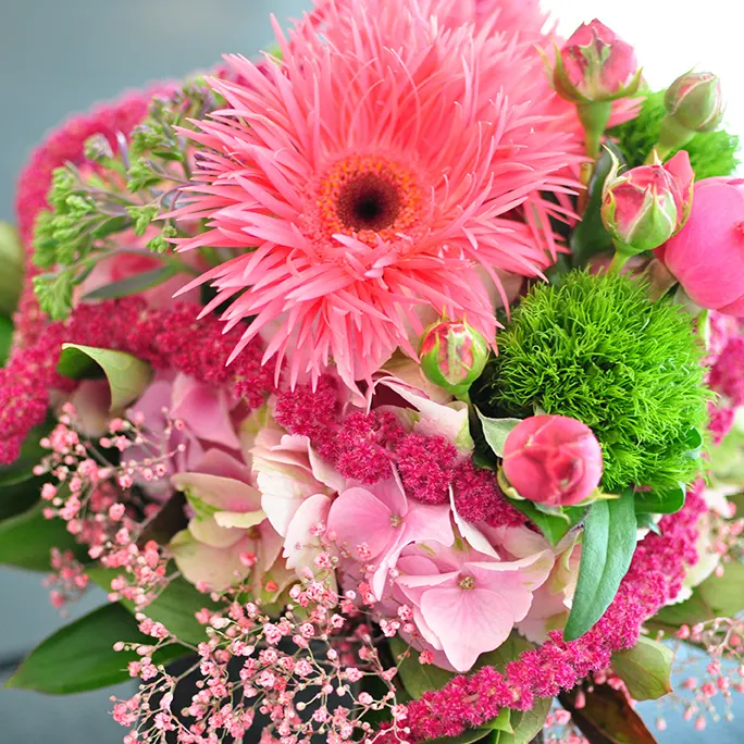 Gesteck mit pinkfarbenen Gerbera und Rosen