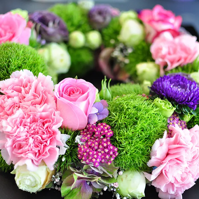Tischgesteck in Rosa, Grün und Violett