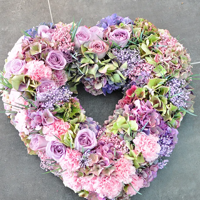 Herzförmiger Trauerkranz in Violett, Rosa und Grau